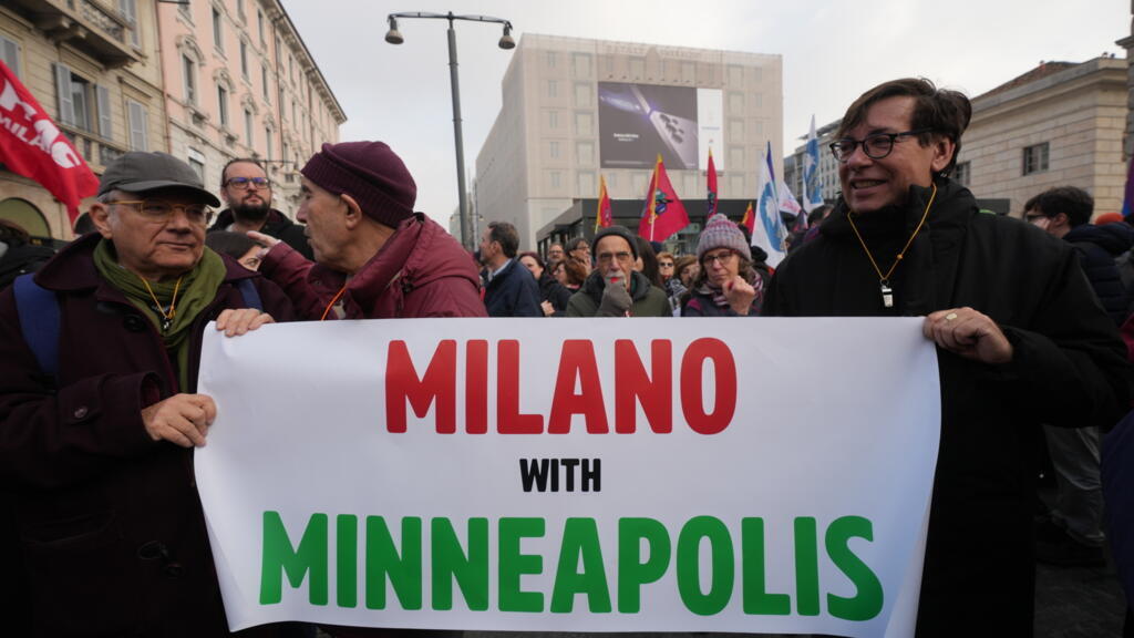 Due italiani in protesta per la presenza di agenti dell'ICE a Milano, sorreggono un manifesto dove c'è scritto "Milano With Minneapolis"
